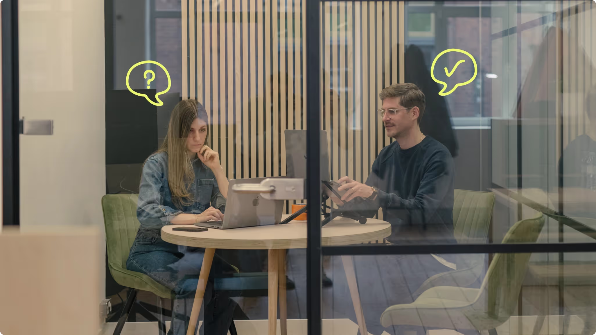 Two people meeting at a round table, with hand-drawn question and tick speech bubbles above them