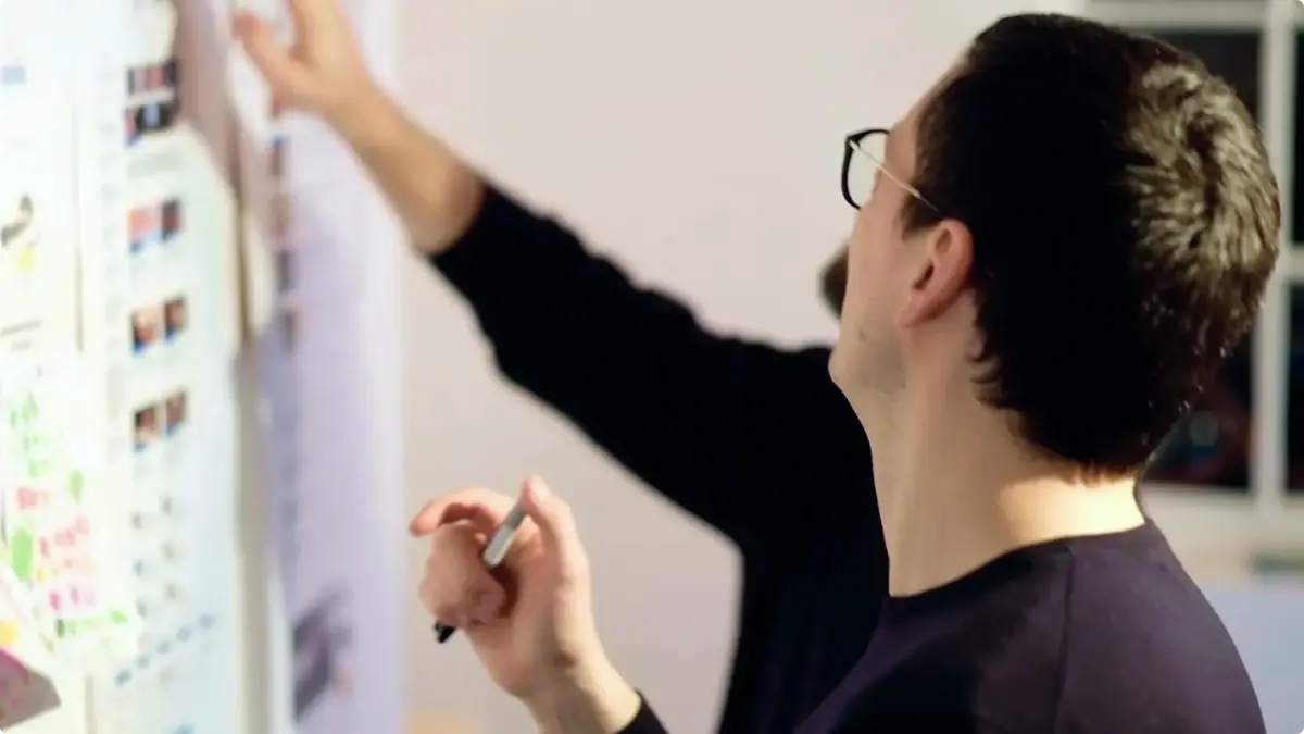 Designer pinning sketches and notes to a wall