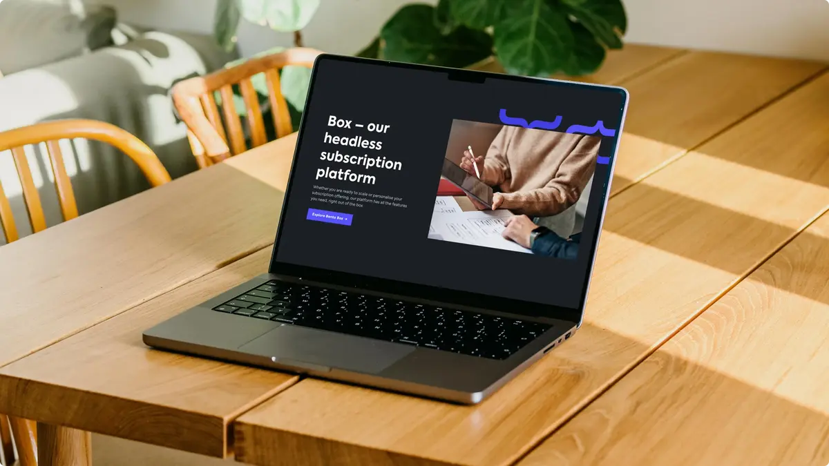 Laptop on a wooden table showing the Bento homepage, 'Box – our headless subscription platform'