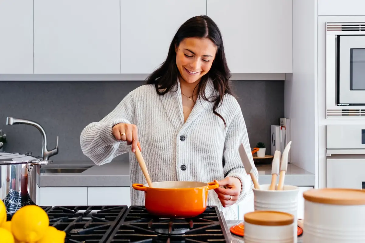 Woman stirring a pot on a kitchen hob