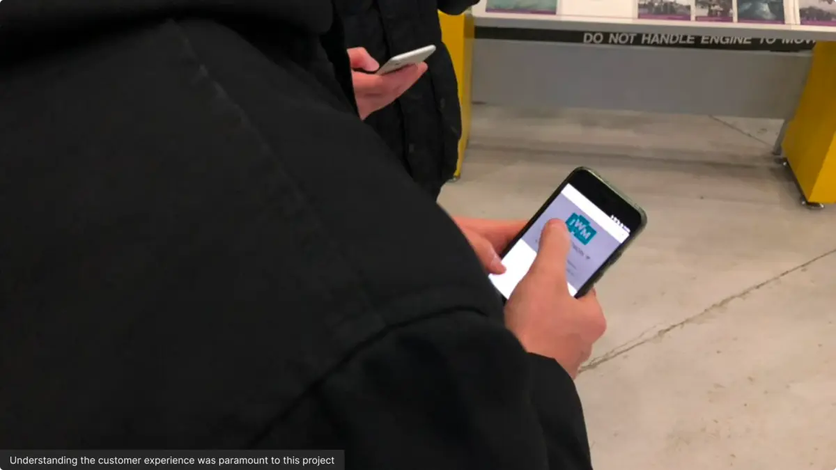Visitor using the IWM website on a phone inside the museum